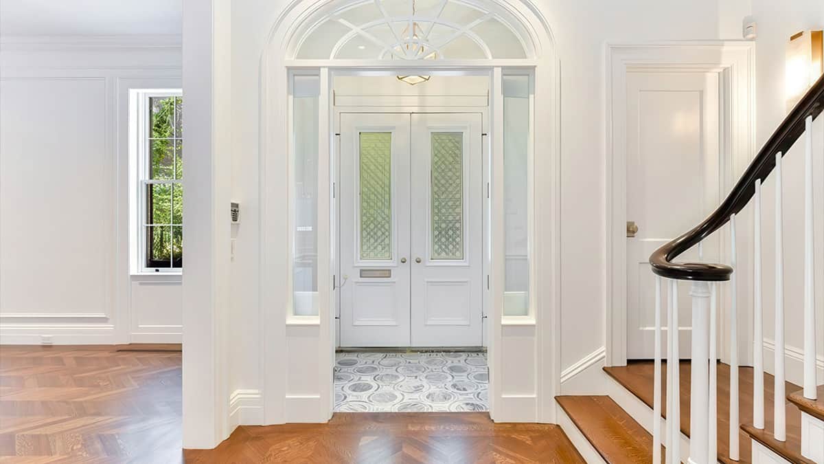 Residential architectural planning and construction administration shown through a finished entry, staircase, and detailed interior coordination