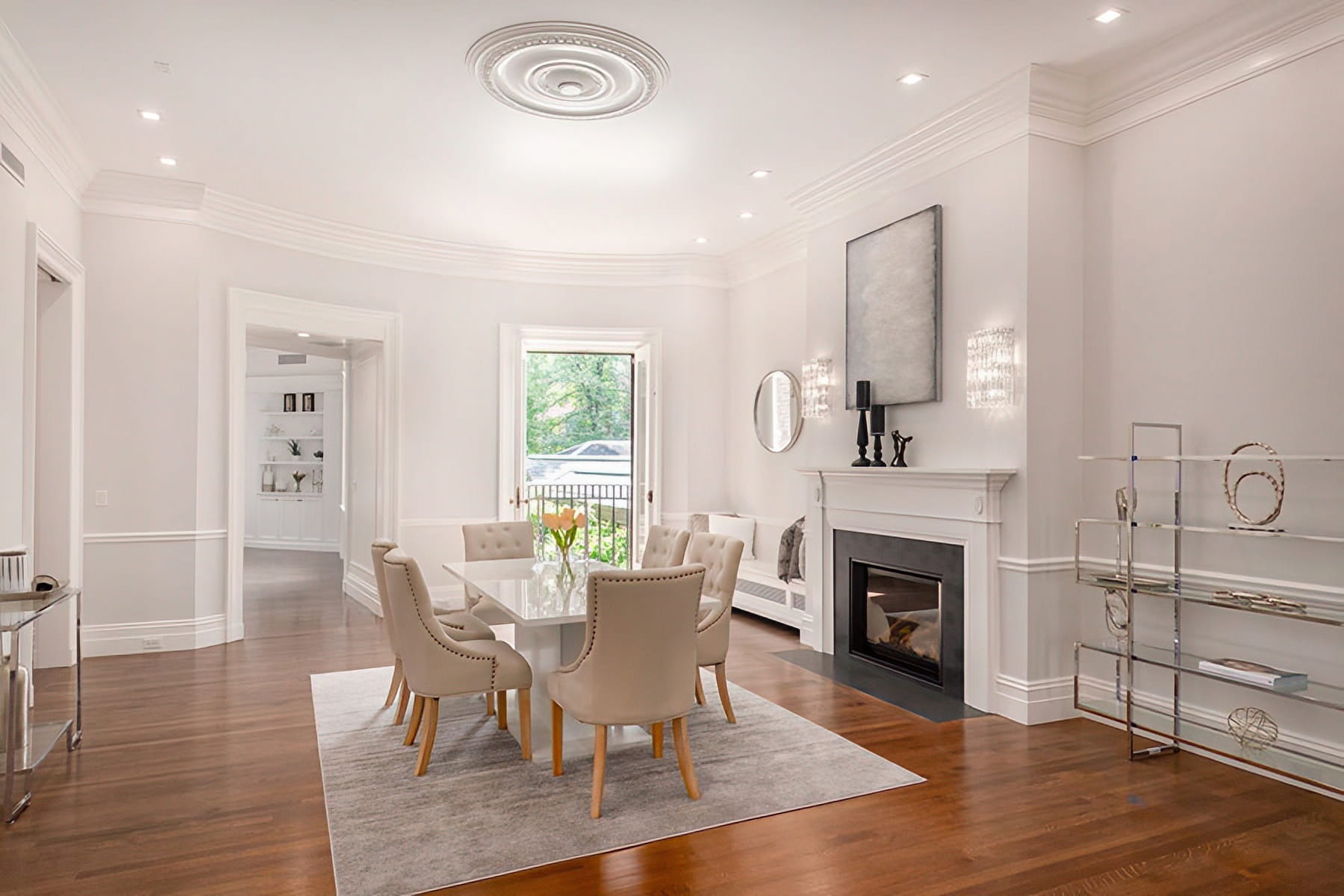 Dining room with a fireplace, ceiling medallion, tall windows, and polished wood floors at the Chestnut Street Residence in Boston.