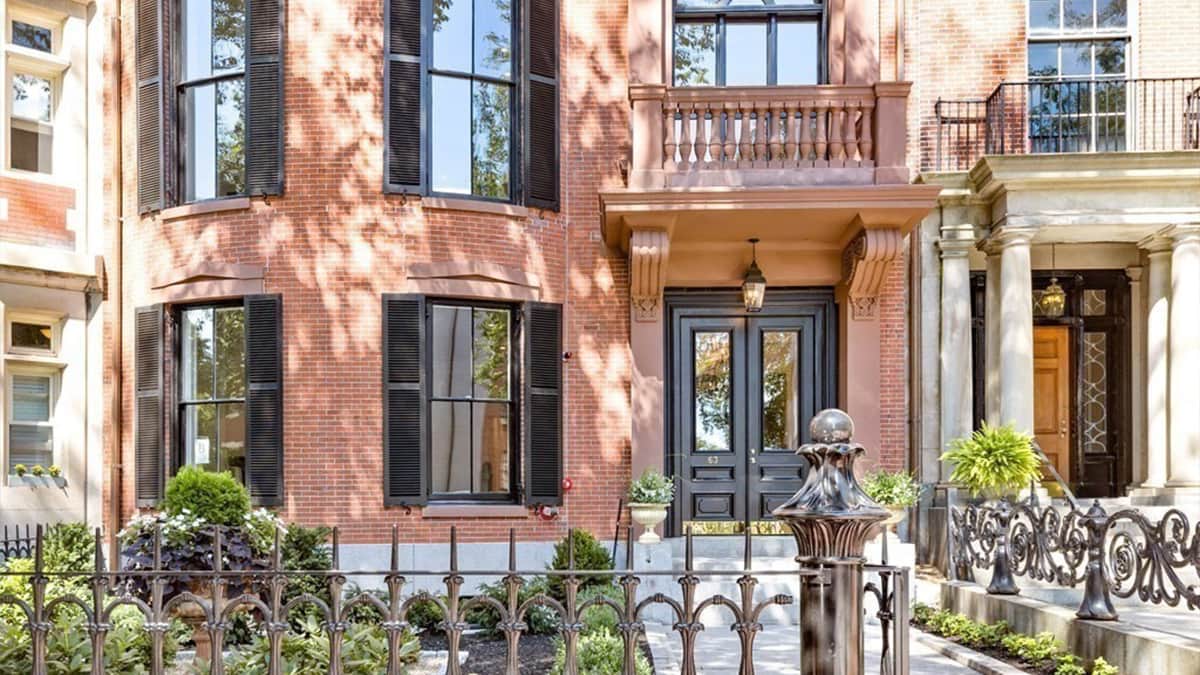 Historic Boston brick residence with restored façade, shutters, ironwork, and classical architectural details