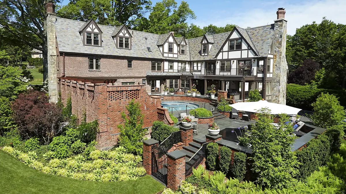 Rear view of the Fieldmont Estate in Belmont, Massachusetts, with Tudor-style architecture, terraces, a pool, and landscaped gardens