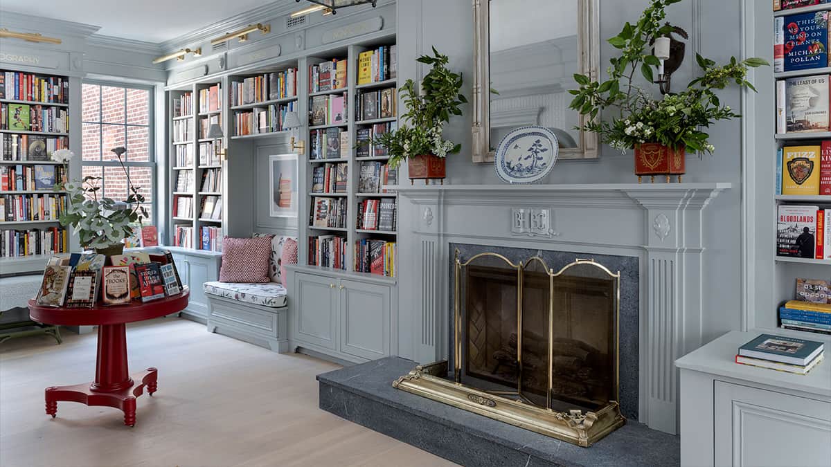 Small-scale commercial bookshop interior in Boston with custom millwork, built-in shelving, fireplace, and architectural detailing