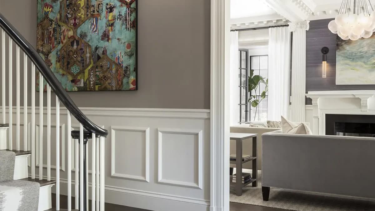 Interior stair hall and living room at the Berkeley Street Residence in Cambridge, Massachusetts, with paneled walls, fireplace, and refined architectural detailing