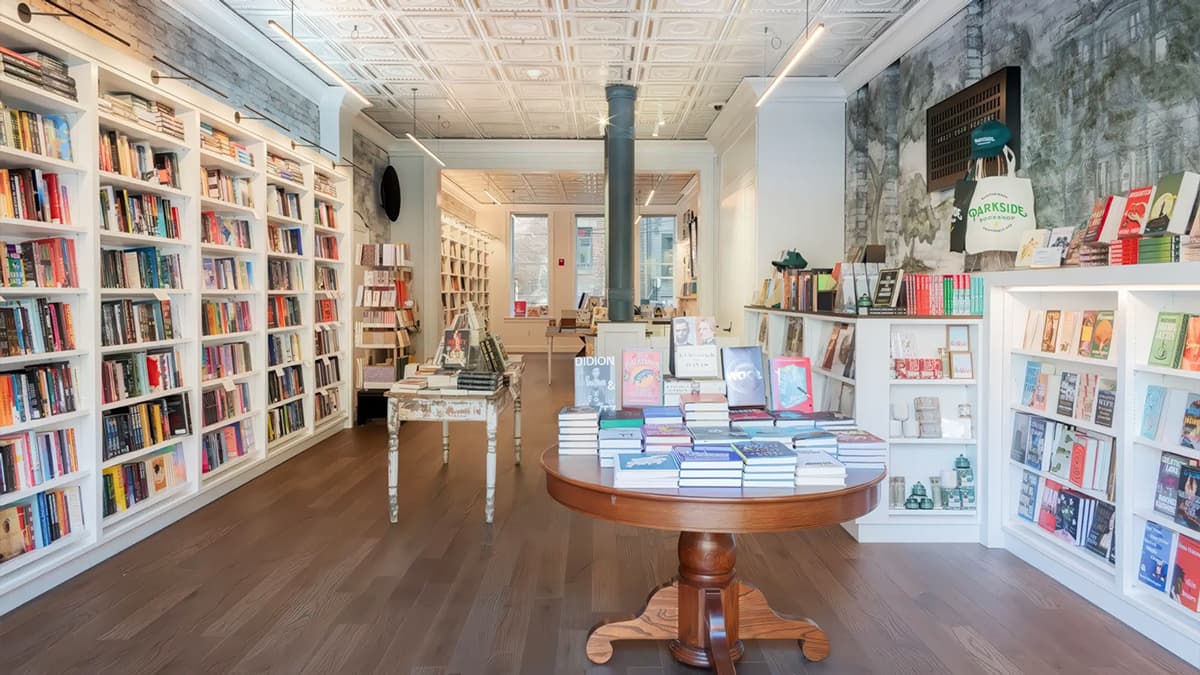 Interior of Parkside Bookshop in Boston with custom bookshelves, display tables, decorative ceiling panels, and retail lighting